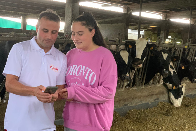 Ignacio Fernández e a súa filla Irene consultando a ficha dunha vaca no seu móbil