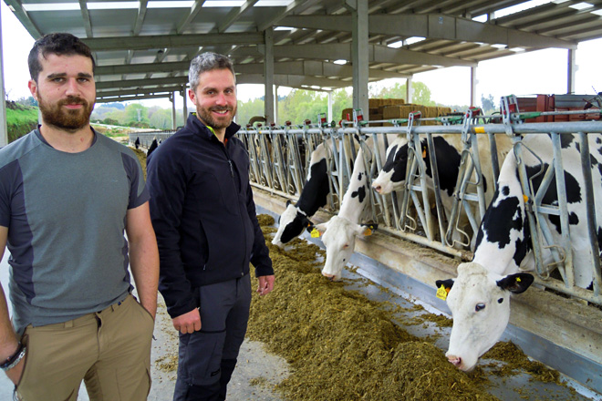 Álex e Marcos, xunto ás súas vacas na nova nave de produción na parroquia de Muxa