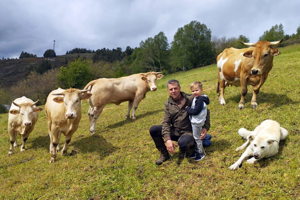 Félix, xunto ao seu fillo Izan, coas vacas da gandería